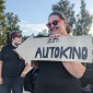Frau mit selbstgebasteltem Wegweiser für das Autokino